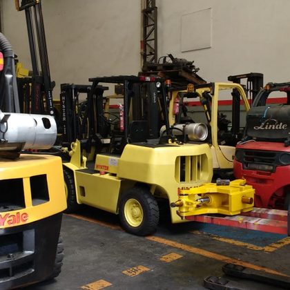 Empilhadeira Hyster em manutenção na oficina, entre máquinas Yale e Linde