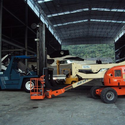 Empilhadeira e plataforma elevatória no galpão
