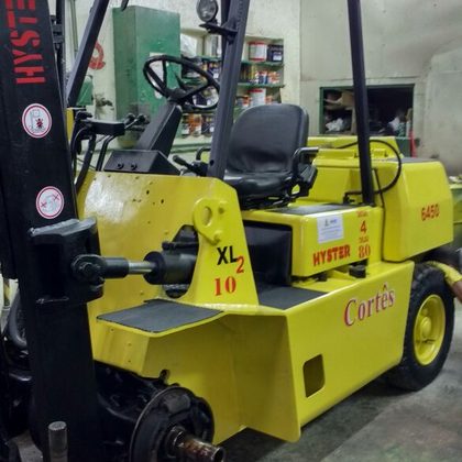 Empilhadeira Hyster na oficina com a roda desmontada para manutenção